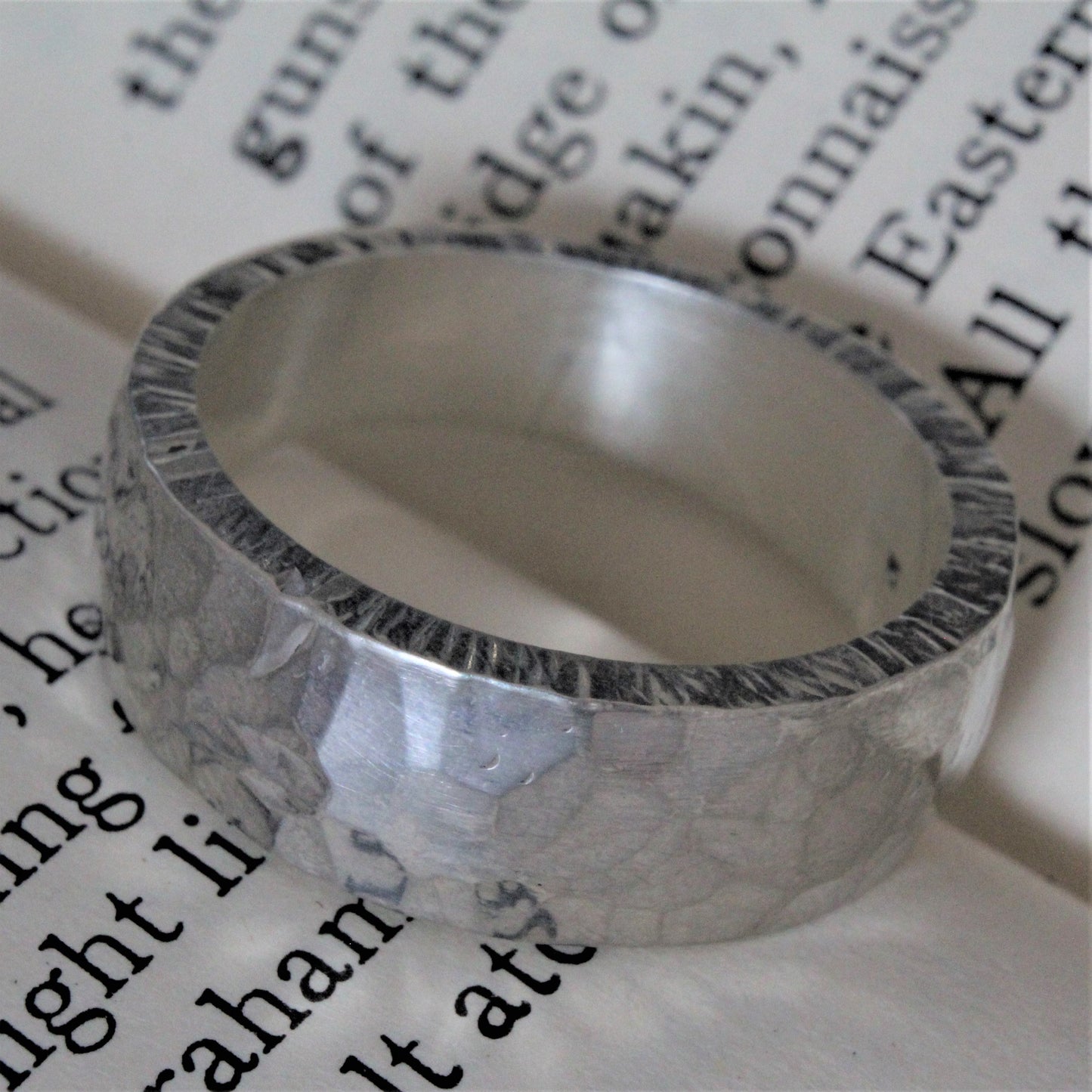 Hand-forged ring crafted from a solid piece of sterling silver with a hammer tone finish. This unique, one-of-a-kind piece features exceptional craftsmanship, intricate detailing, and a polished surface