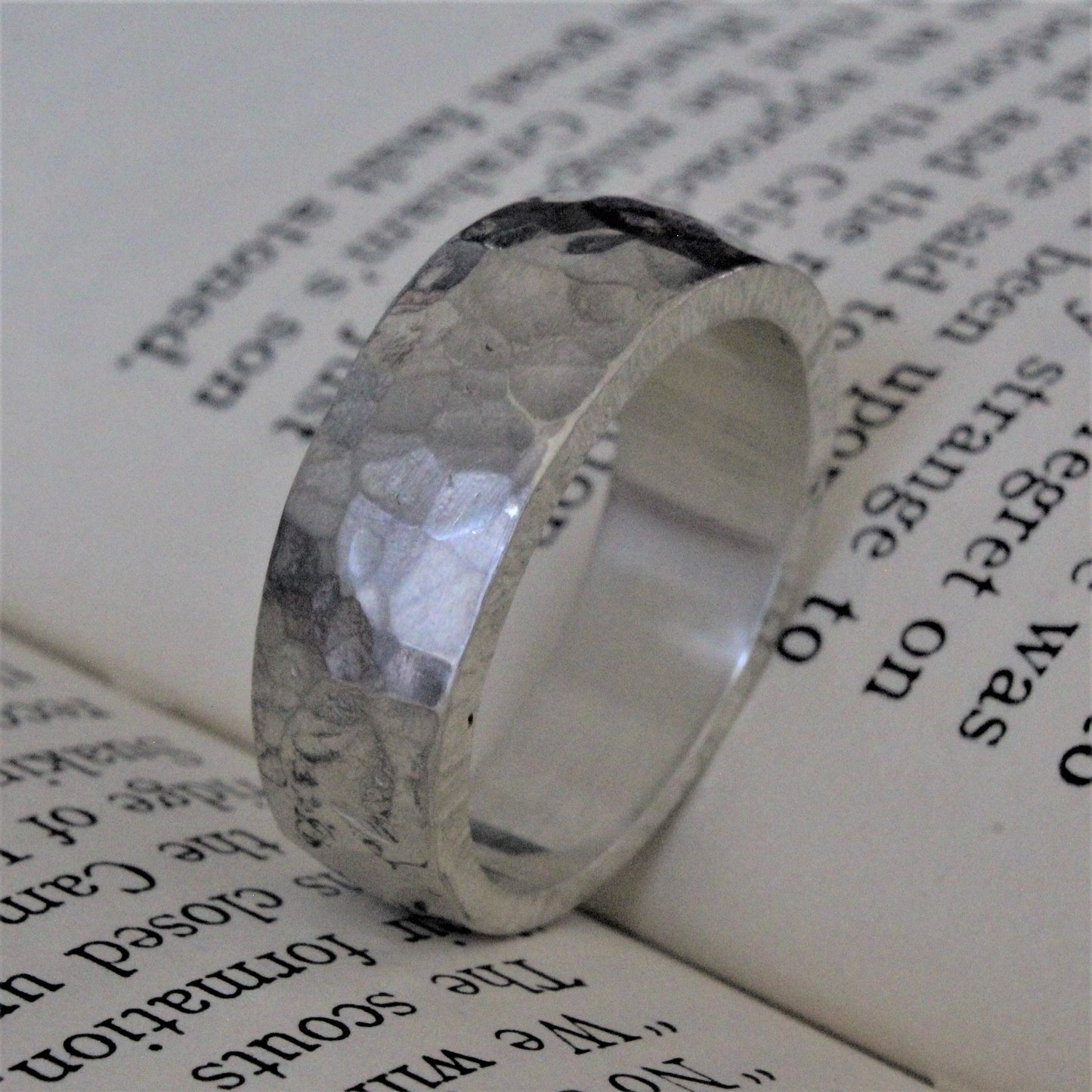 Hand-forged ring crafted from a solid piece of sterling silver with a hammer tone finish. This unique, one-of-a-kind piece features exceptional craftsmanship, intricate detailing, and a polished surface