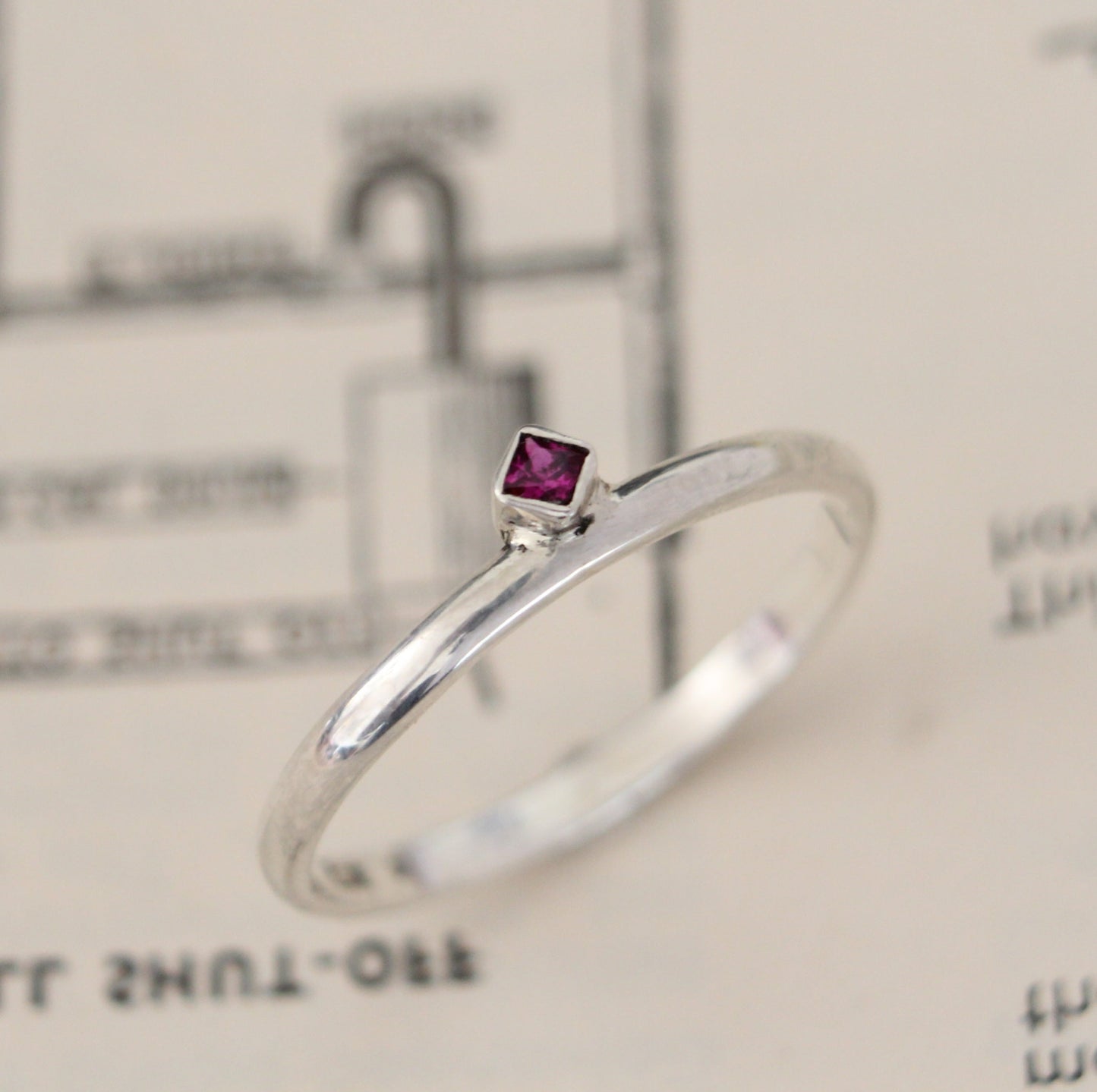 Handmade sterling silver ring with a bezel-set princess-cut ruby, showcasing a blend of modern design and timeless elegance. Thoughtfully crafted with intricate detail, perfect for both everyday wear and special occasions