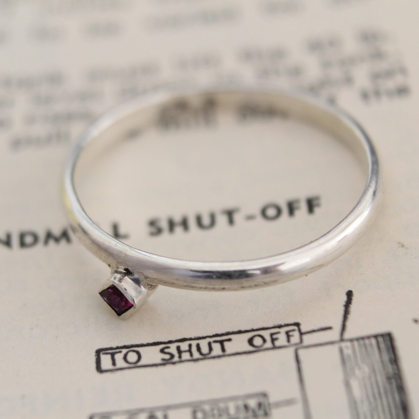 Handmade sterling silver ring with a bezel-set princess-cut ruby, showcasing a blend of modern design and timeless elegance. Thoughtfully crafted with intricate detail, perfect for both everyday wear and special occasions
