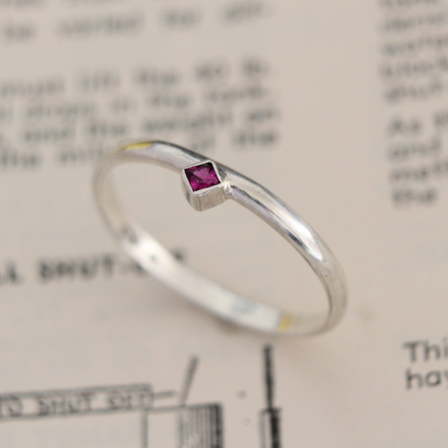 Handmade sterling silver ring with a bezel-set princess-cut ruby, showcasing a blend of modern design and timeless elegance. Thoughtfully crafted with intricate detail, perfect for both everyday wear and special occasions