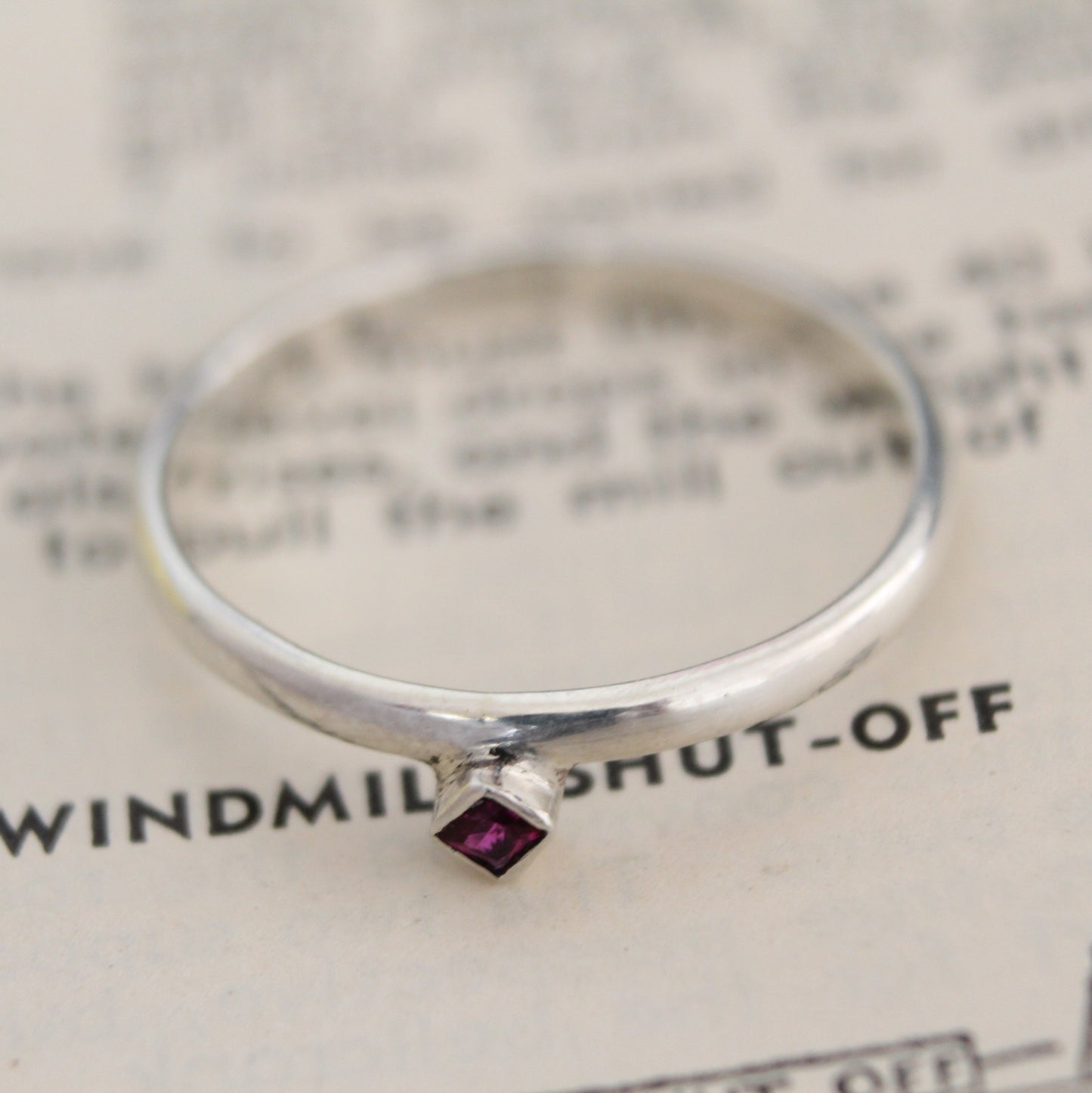 Handmade sterling silver ring with a bezel-set princess-cut ruby, showcasing a blend of modern design and timeless elegance. Thoughtfully crafted with intricate detail, perfect for both everyday wear and special occasions