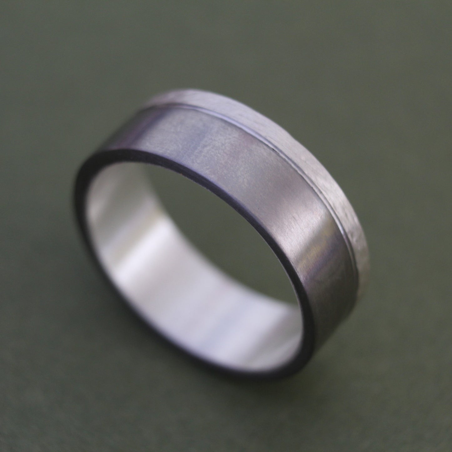 Men's Ring with a brushed titanium band and a textured sterling silver inlay, combining modern sleekness with sophisticated detail for a bold, elegant design.