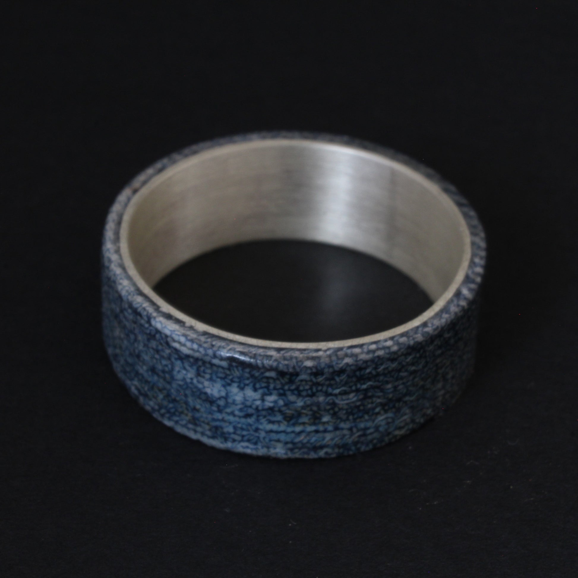 Denim and Sterling Silver Ring featuring a textured denim inlay with a sleek sterling silver band, combining casual and elegant elements for a unique, comfortable accessory.