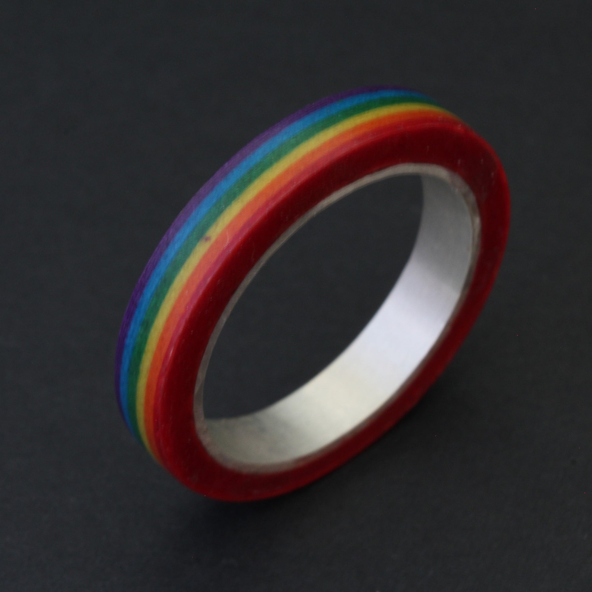 Handcrafted sterling silver band with vibrant LGBTQ+ colours, encased in resin and layered paper, celebrating pride and individuality
