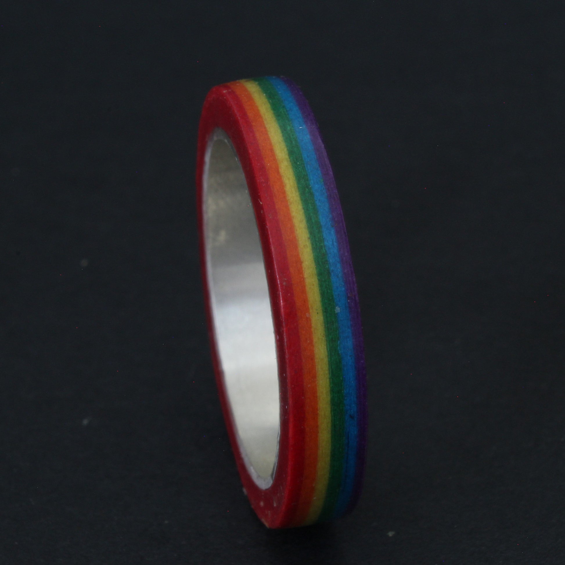 Handcrafted sterling silver band with vibrant LGBTQ+ colours, encased in resin and layered paper, celebrating pride and individuality