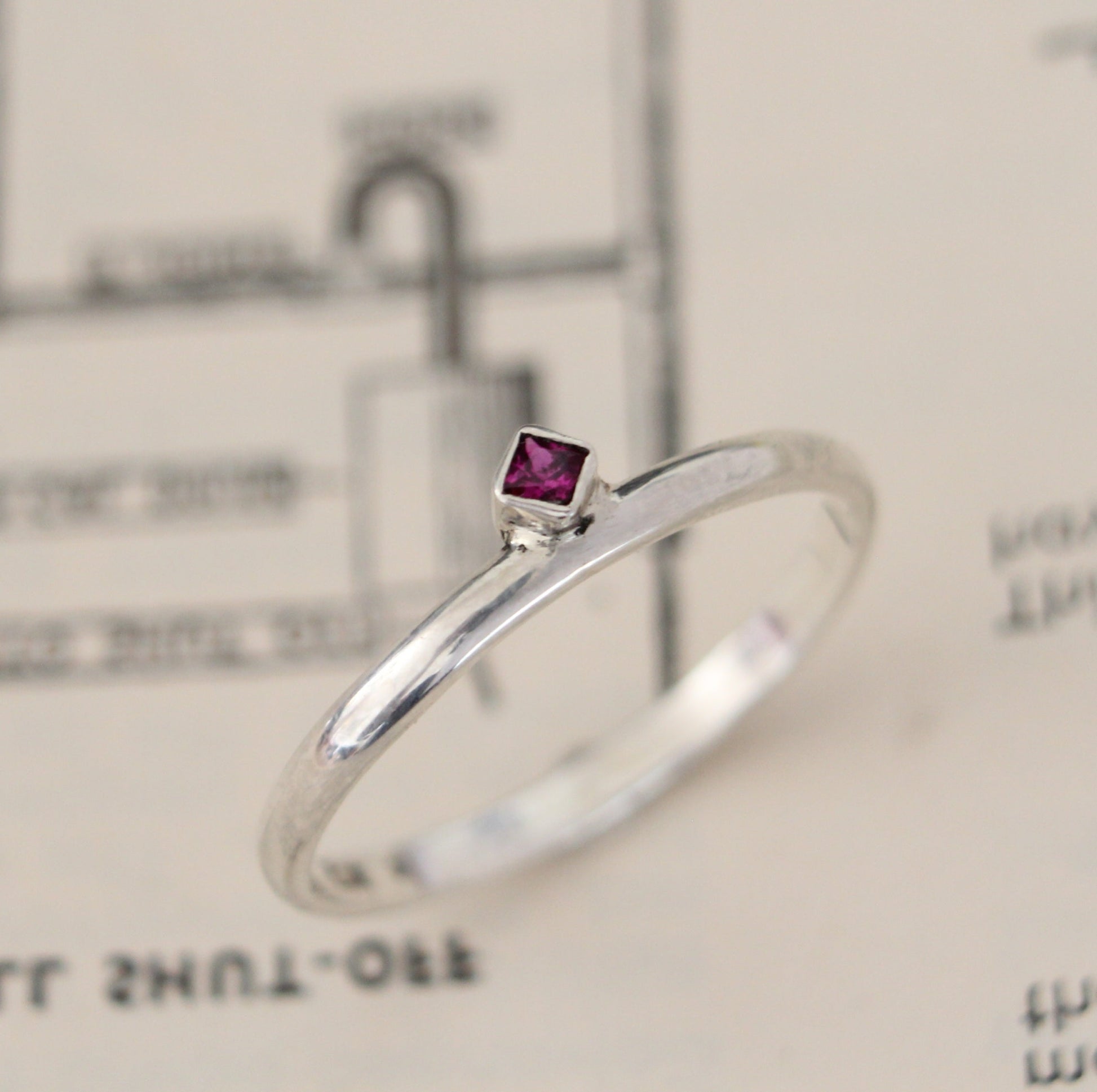 Handmade sterling silver ring with a bezel-set princess-cut ruby, showcasing a blend of modern design and timeless elegance. Thoughtfully crafted with intricate detail, perfect for both everyday wear and special occasions
