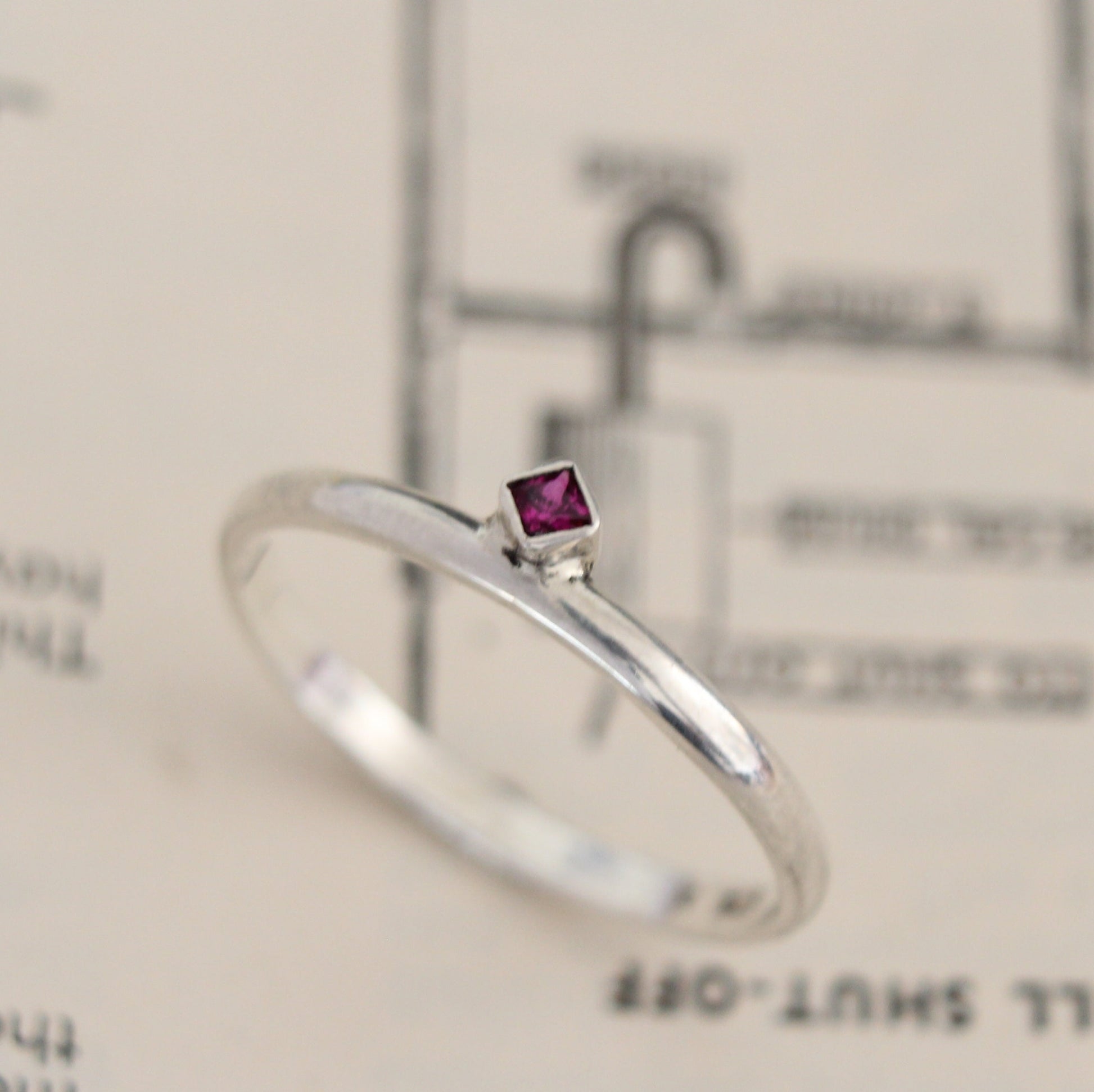 Handmade sterling silver ring with a bezel-set princess-cut ruby, showcasing a blend of modern design and timeless elegance. Thoughtfully crafted with intricate detail, perfect for both everyday wear and special occasions