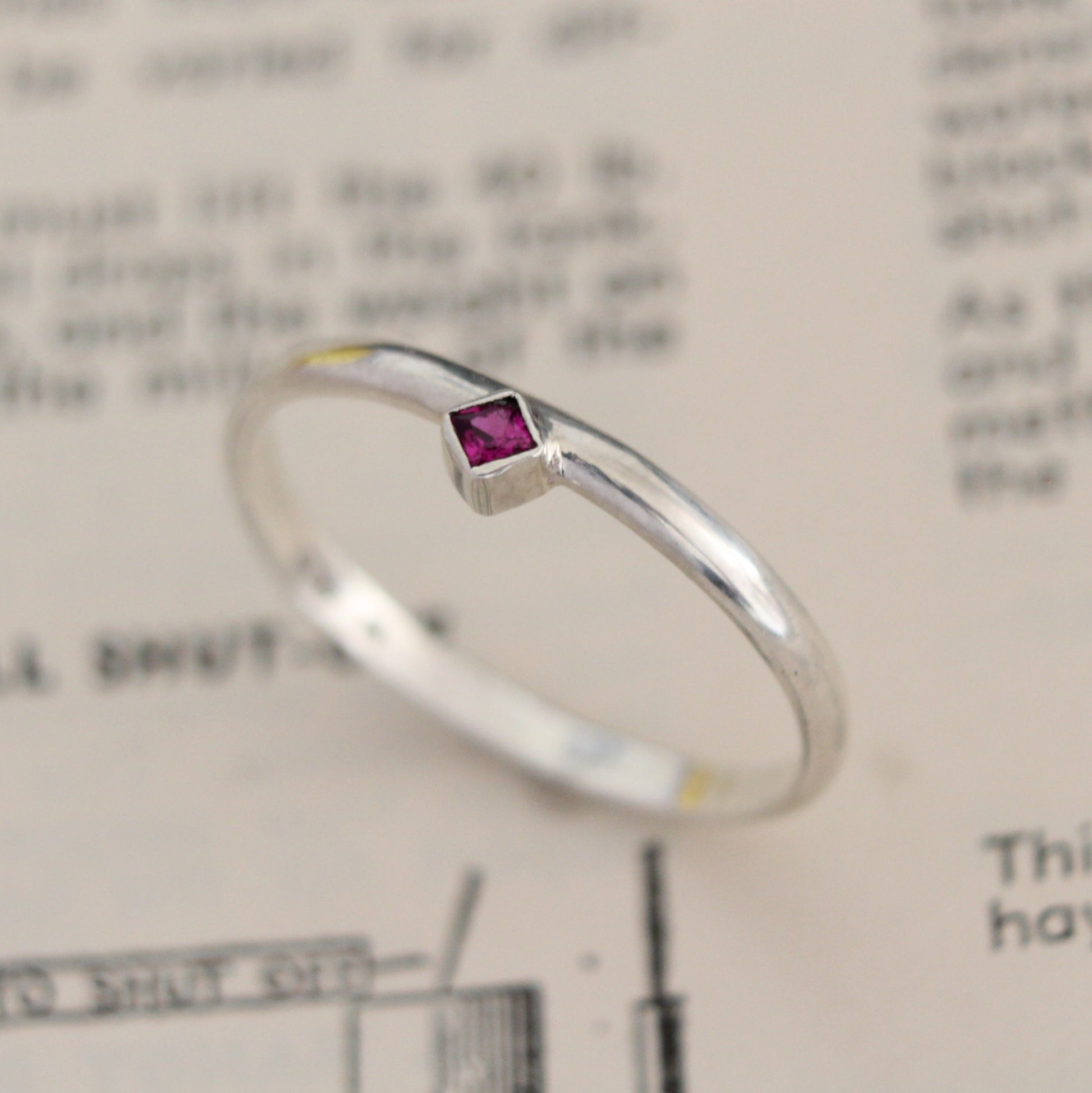 Handmade sterling silver ring with a bezel-set princess-cut ruby, showcasing a blend of modern design and timeless elegance. Thoughtfully crafted with intricate detail, perfect for both everyday wear and special occasions