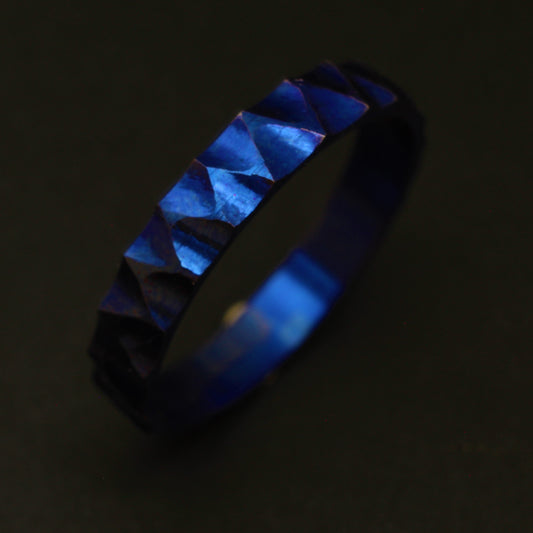 Anodized Titanium Ring with a vibrant blue hue, featuring a ridged and valley pattern for a sophisticated and elegant design.